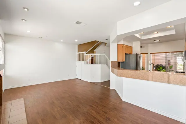 a view of a big room with wooden floor and windows