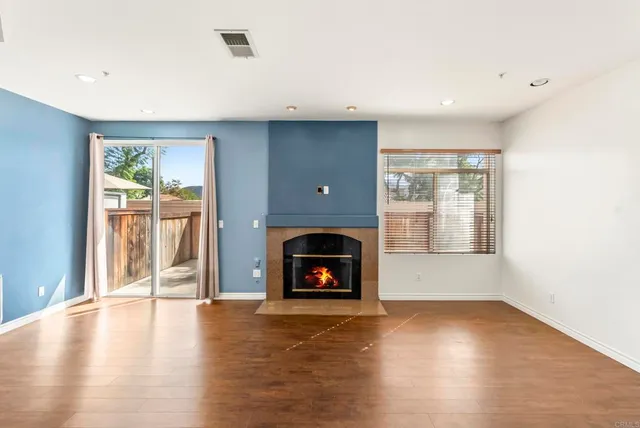 an empty room with floor to ceiling window and fireplace
