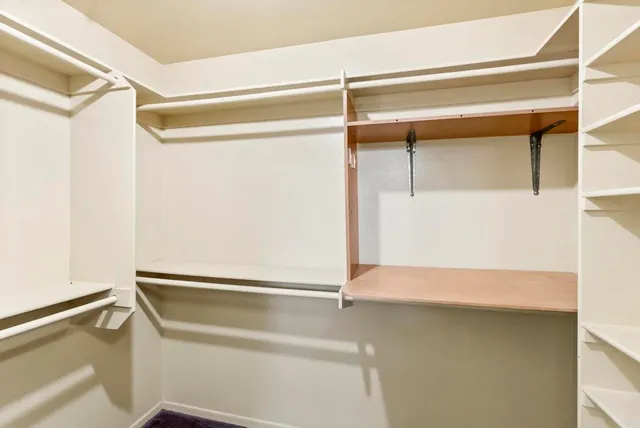a view of walk in closet with empty racks