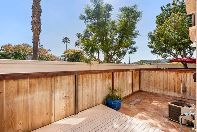 a view of a balcony with table and chairs and wooden fence
