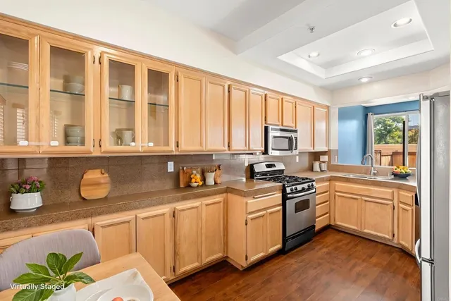 a kitchen with a sink wooden cabinets and stainless steel appliances