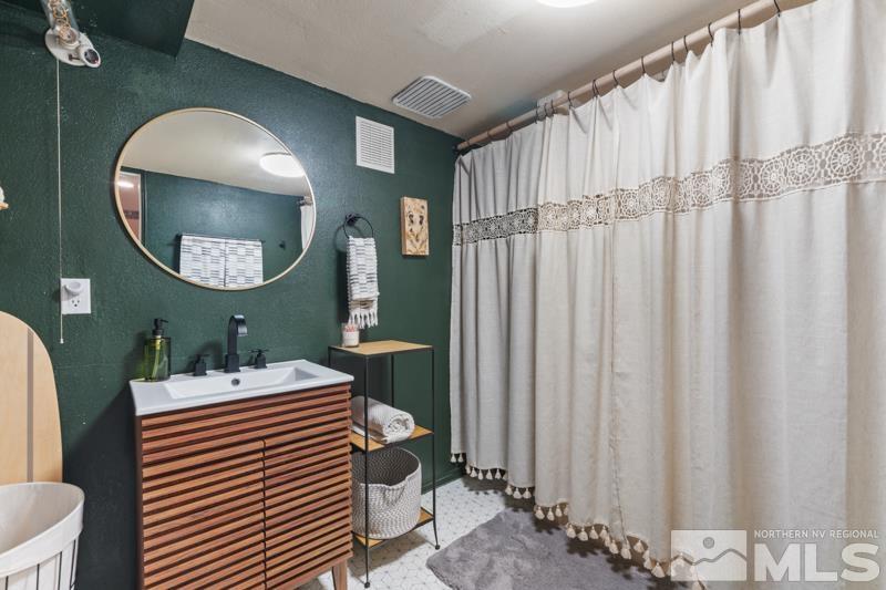 1451 Forest Street Reno, NV 89509 - Photo 16 of 23 a bathroom with a sink a mirror and a toilet