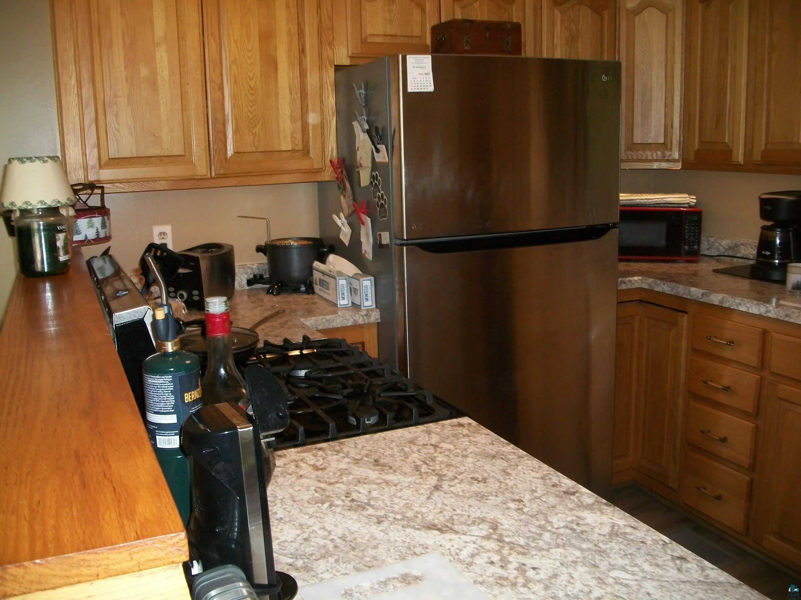3917 Highway 5 Hibbing, MN 55746 - Photo 9 of 36 Kitchen with freestanding refrigerator, light countertops, and black microwave