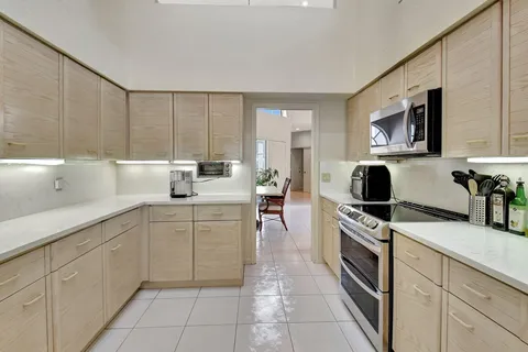 a kitchen with white cabinets a sink dishwasher and a stove top oven