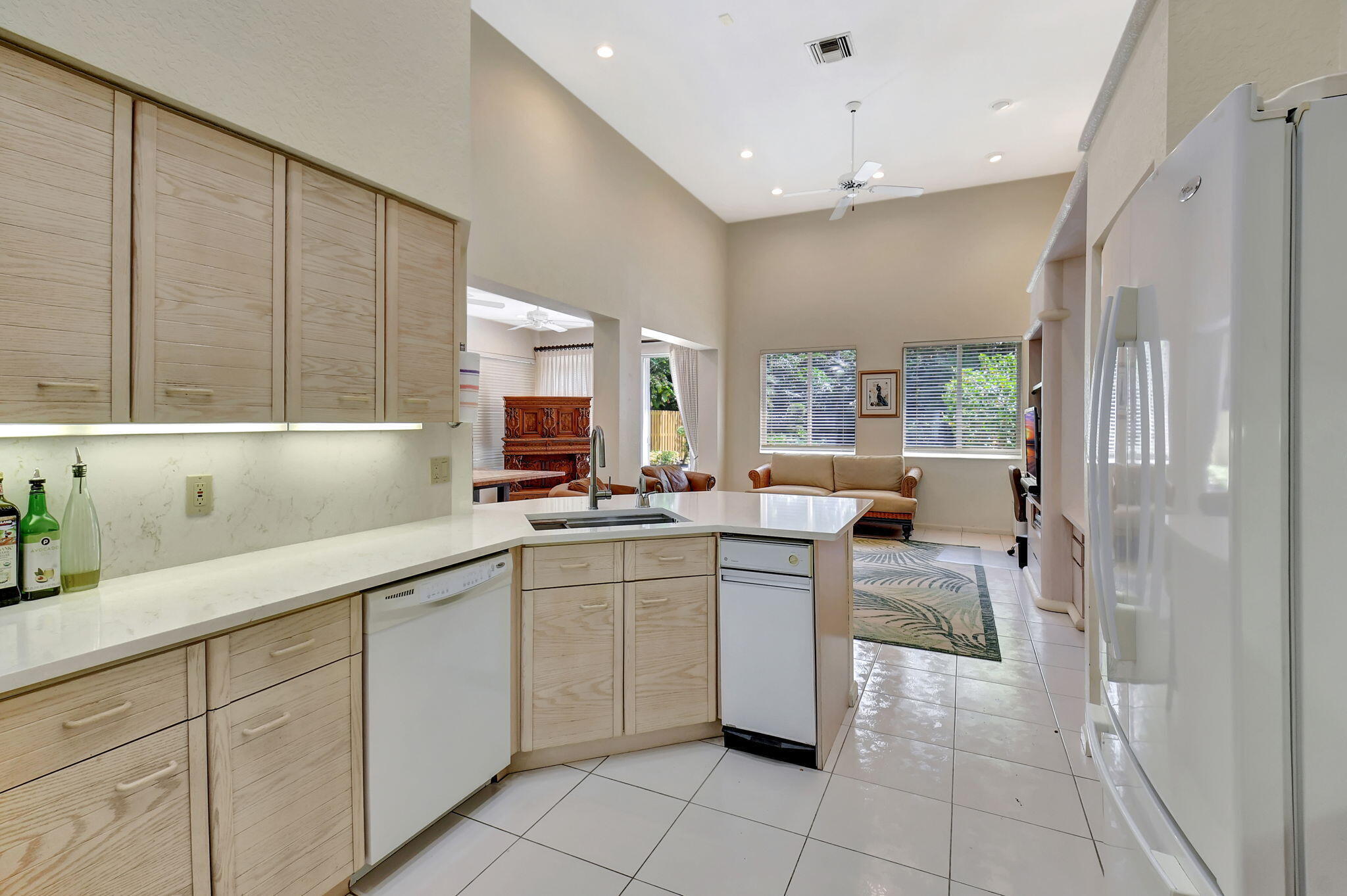 2462 Northwest 66th Drive Boca Raton, FL 33496 - Photo 20 of 49 a kitchen with cabinets a sink dining table and chairs
