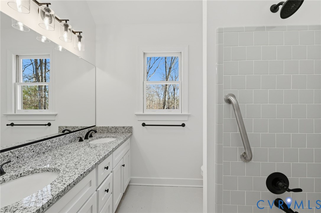 3264 Sherwood Ridge Way Powhatan, VA 23139 - Photo 22 of 40 a bathroom with a granite countertop sink a mirror and shower