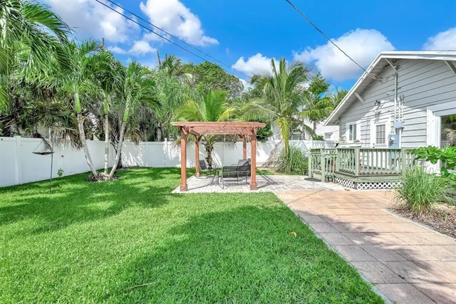 a view of a chair and table in backyard of the house