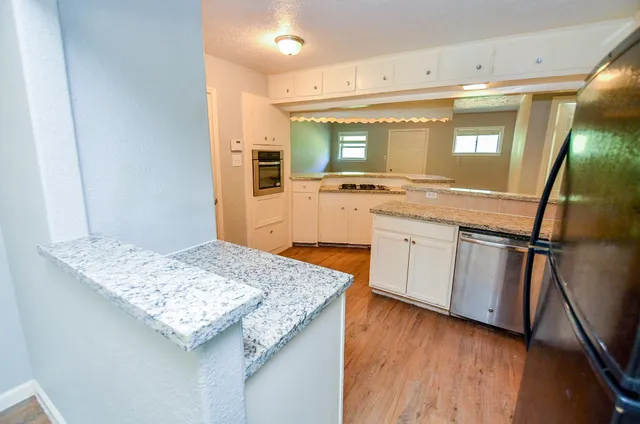 a kitchen with stainless steel appliances granite countertop a sink stove and refrigerator