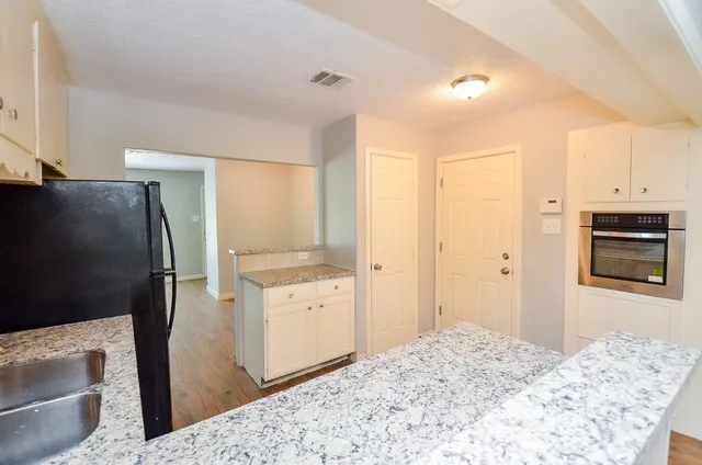 a bedroom with a bed and a refrigerator in it