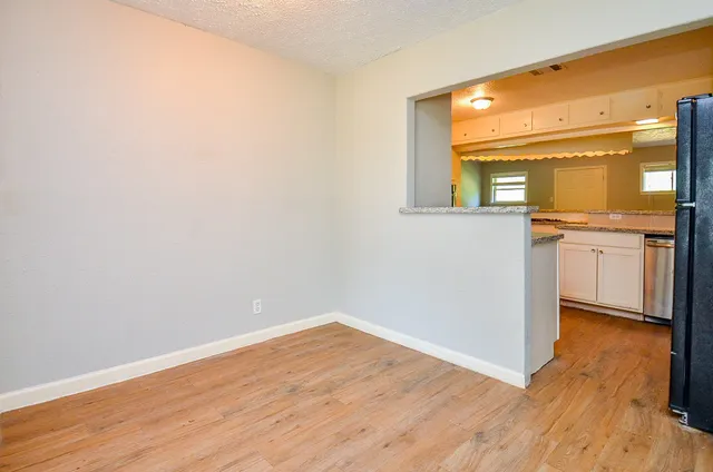 a view of a kitchen with wooden floor and a large window
