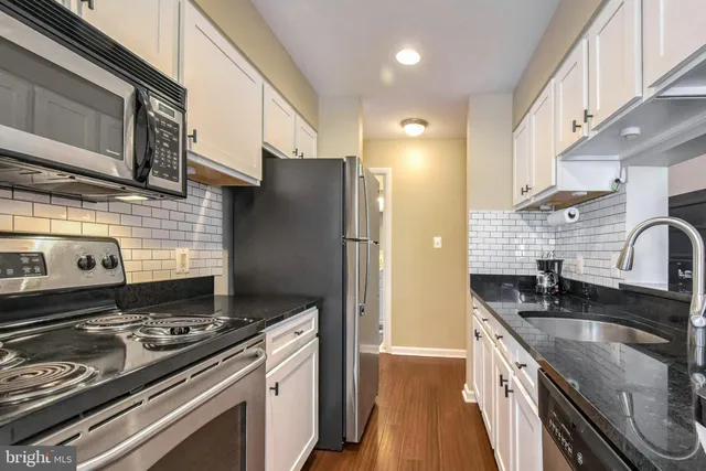 a kitchen with stainless steel appliances granite countertop a stove and a refrigerator
