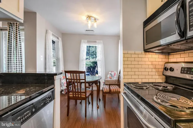 a kitchen with a stove a sink and chairs
