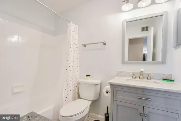 a bathroom with a toilet a sink a vanity and mirror