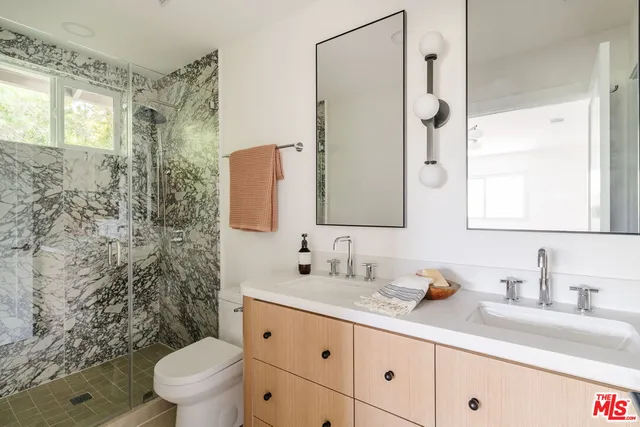 a bathroom with a granite countertop sink mirror vanity and toilet