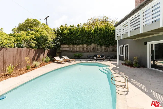a swimming pool with outdoor seating and yard