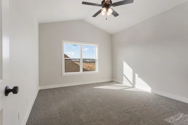 an empty room with closet and a chandelier fan