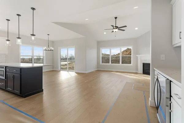 a large kitchen with kitchen island a stove a sink a refrigerator and a wooden floor