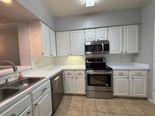 a kitchen with cabinets stainless steel appliances and a sink