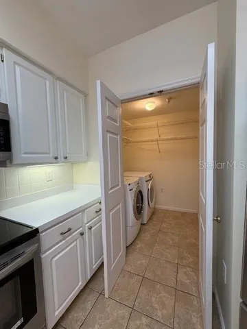 a utility room with cabinets washer and dryer