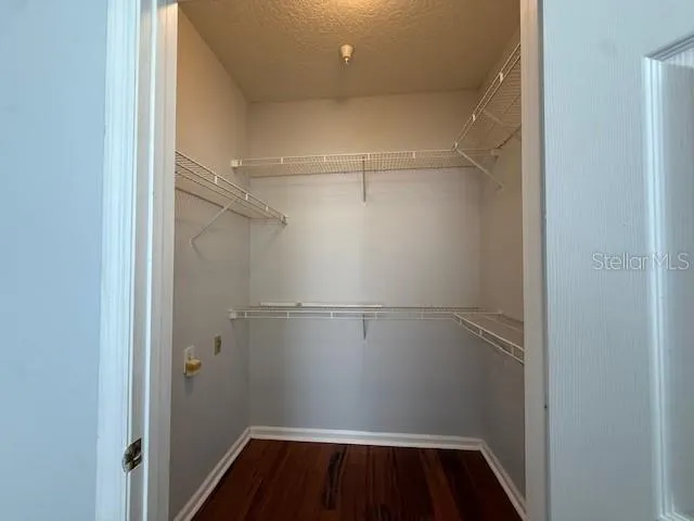 a view of walk in closet with wooden floor
