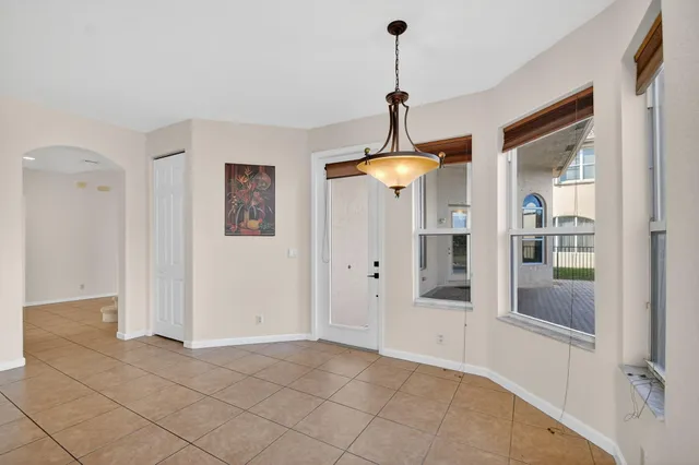 an empty room with windows and ceiling fan
