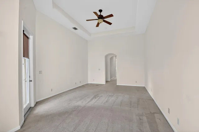 an empty room with a window and a fan