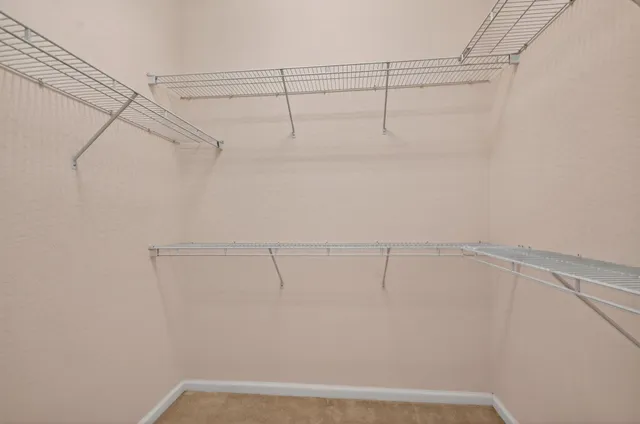 an empty room with a ceiling fan and carpet