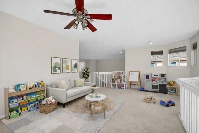 a view of an empty room with window and a ceiling fan