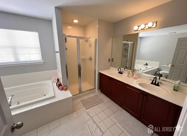 a spacious bathroom with a bathtub sink and mirror