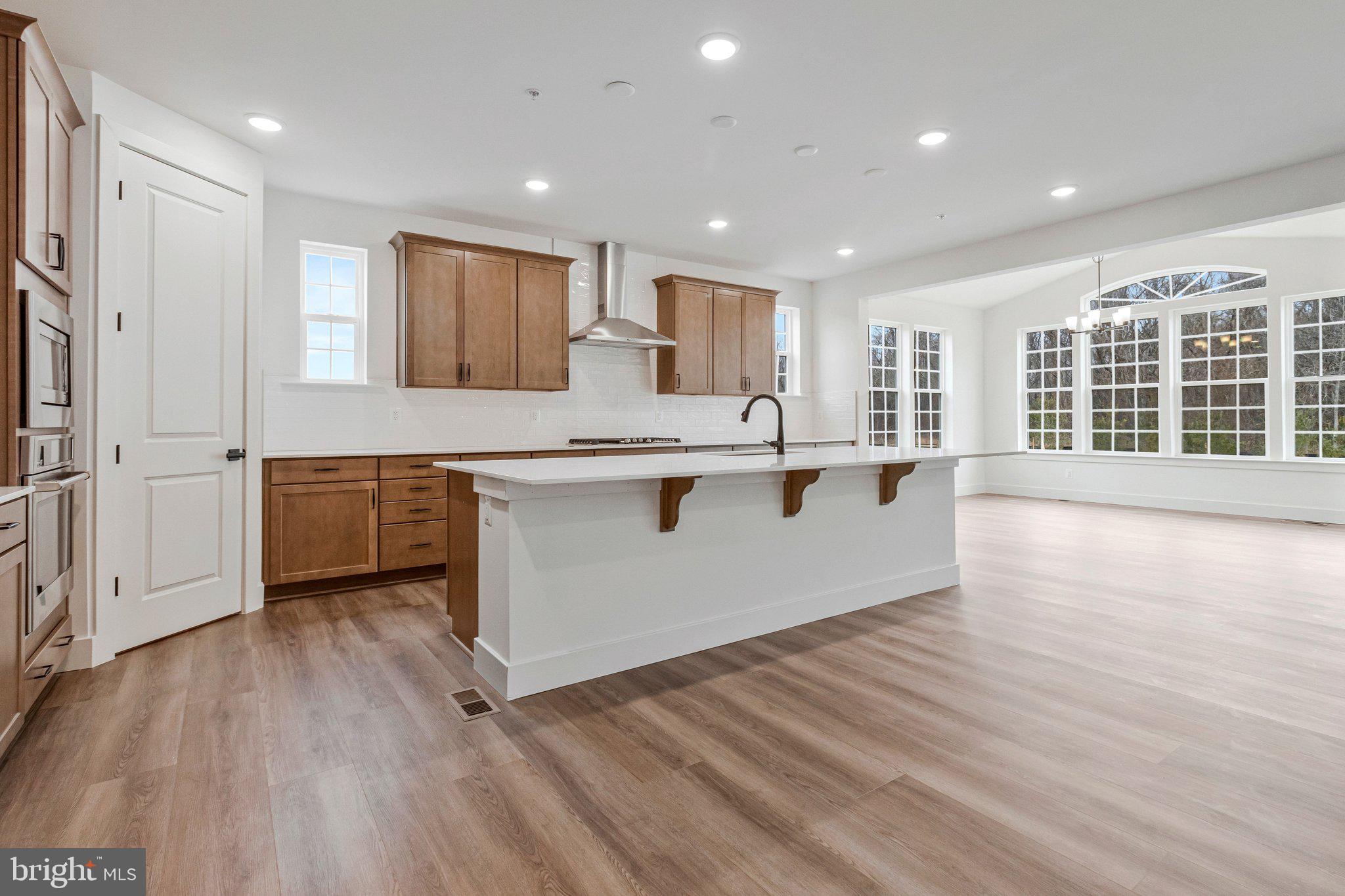 2013 St James Road Accokeek, MD 20607 - Photo 25 of 80 a large white kitchen with kitchen island a island wooden floor and a refrigerator
