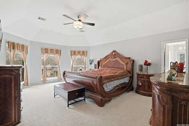 a bedroom with a bed chandelier and a window