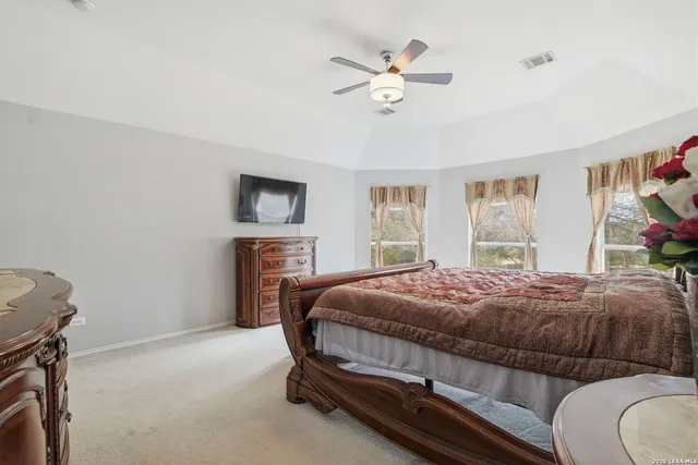 a bedroom with a bed a chandelier and dresser
