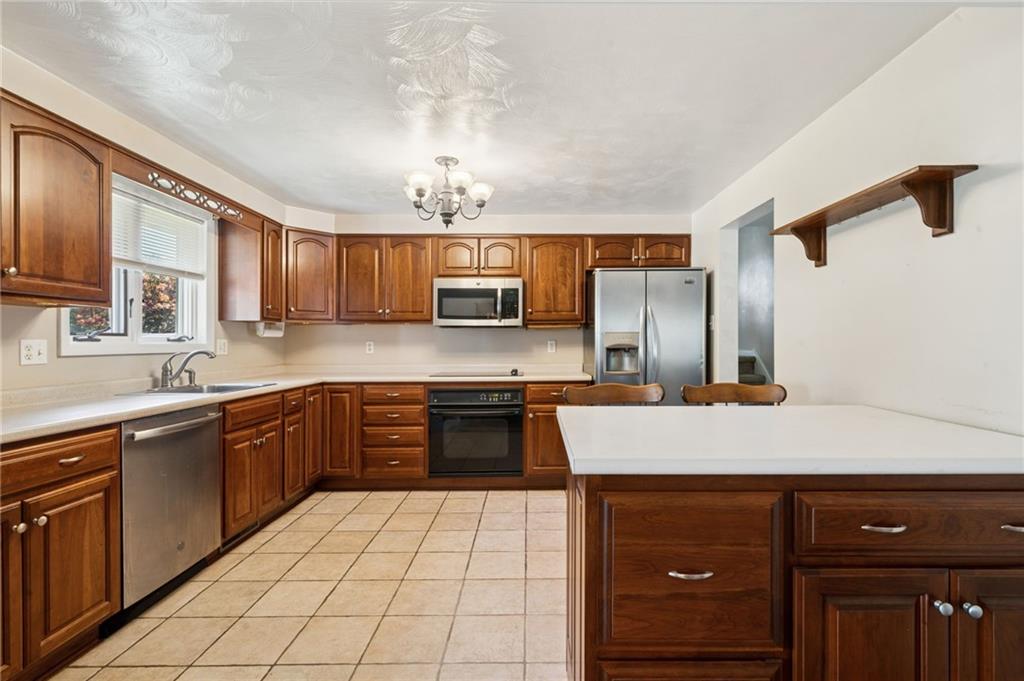 1722 Arona Road Irwin, PA 15642 - Photo 13 of 33 a large kitchen with stainless steel appliances granite countertop a sink and cabinets