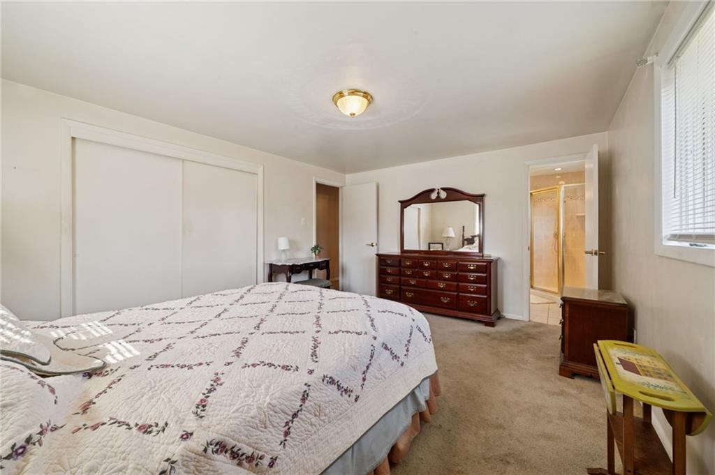 1722 Arona Road Irwin, PA 15642 - Photo 18 of 33 a spacious bedroom with a bed a couch and a chandelier