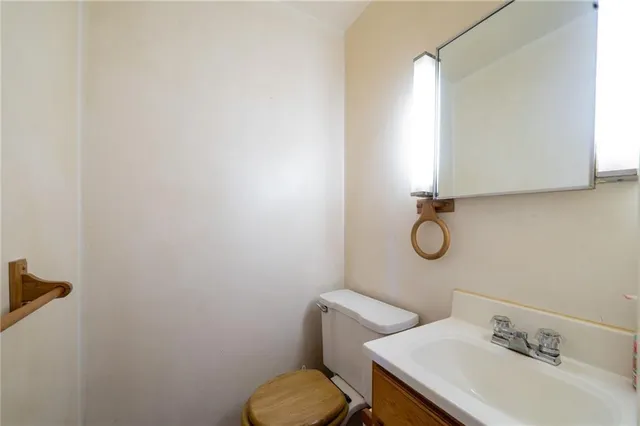 a bathroom with a sink mirror and toilet