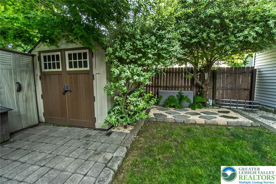 365 Rock Street Easton, PA 18042 - Photo 40 of 50 A quaint storage shed with inviting double doors sits beside a well-maintained lawn and stone pathway.