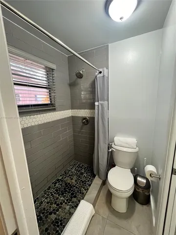 a bathroom with a toilet and a shower