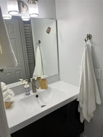 a bathroom with a sink vanity and tub