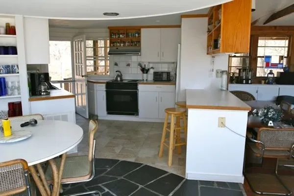a kitchen with kitchen island a stove a table and chairs in it