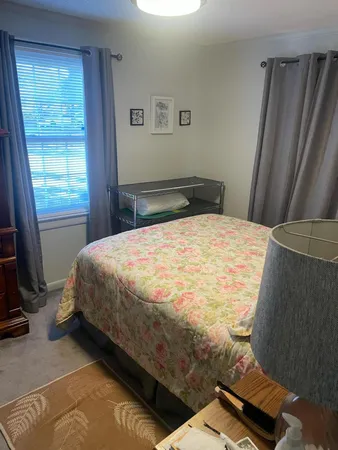 a bed sitting in a bedroom next to a window