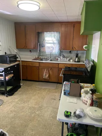 a kitchen with kitchen island granite countertop a sink cabinets and window