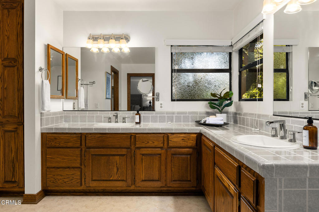 23 Hidden Valley Road Monrovia, CA 91016 - Photo 21 of 27 a bathroom with a granite countertop sink a large mirror a and window