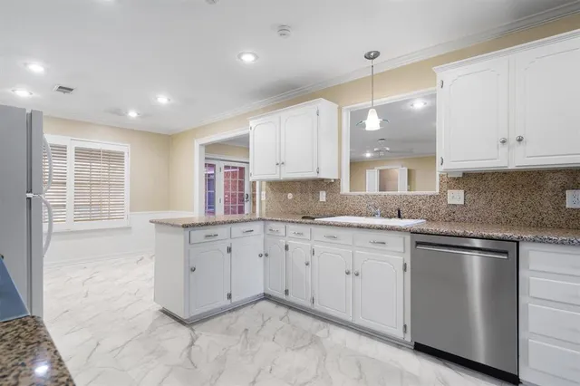 a kitchen with granite countertop white cabinets and white appliances