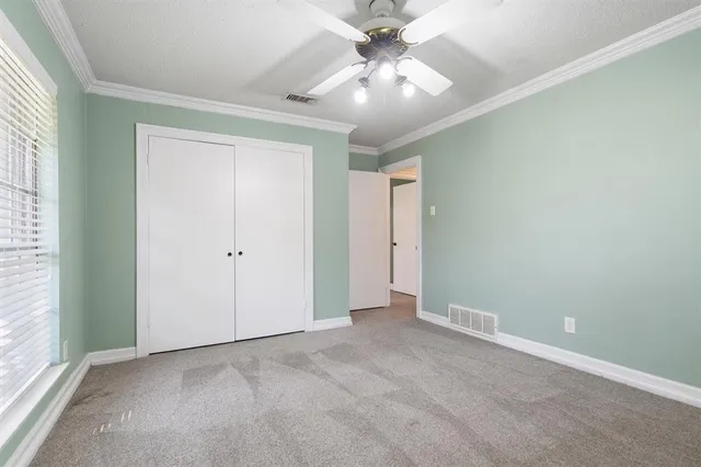 an empty room with a ceiling fan and a window
