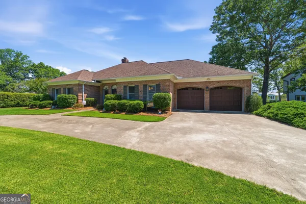 a front view of a house with a yard and potted plants
