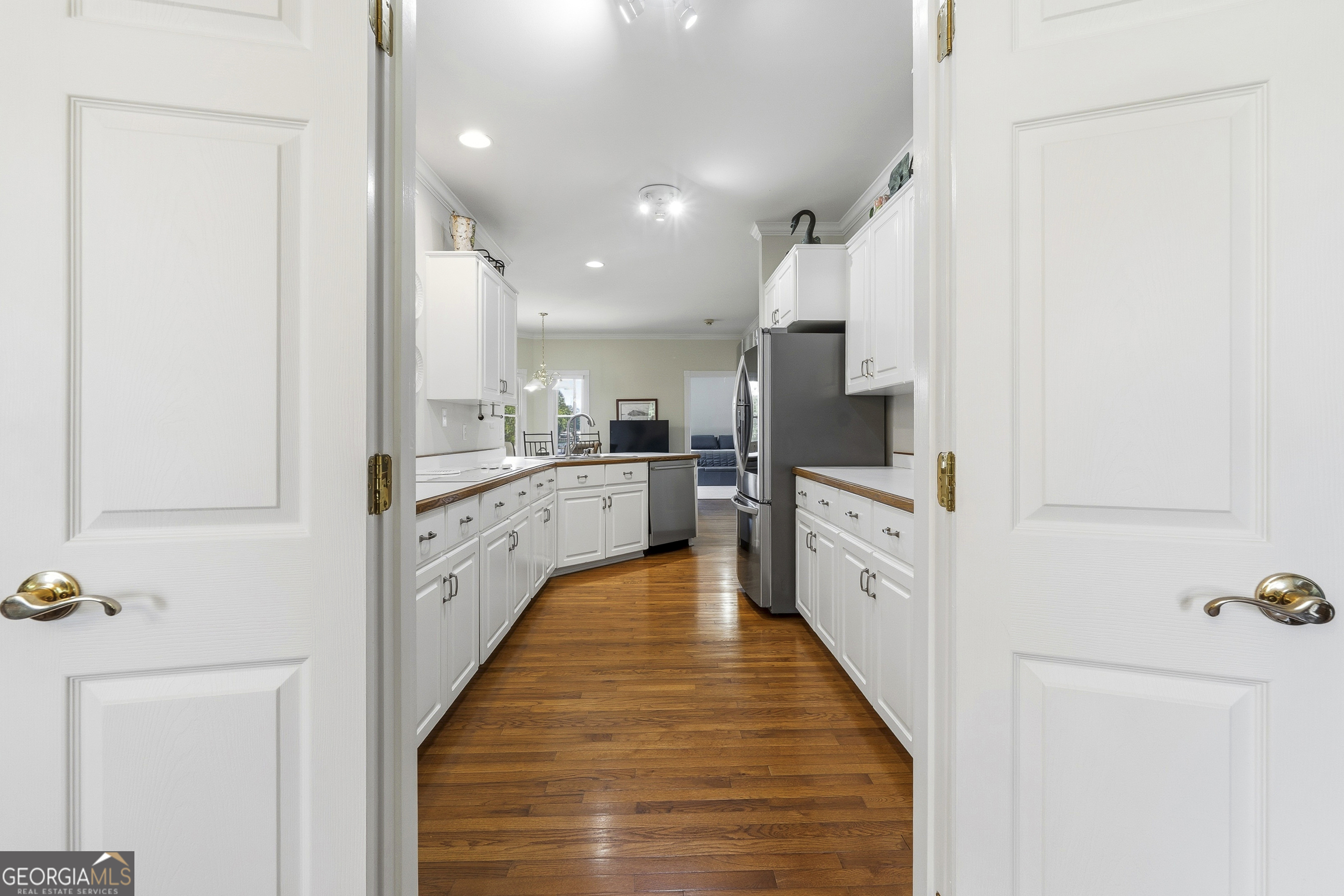 104 Spruce Point Southeast Eatonton, GA 31024 - Photo 13 of 63 a large white kitchen with kitchen island a sink a counter top space and stainless steel appliances