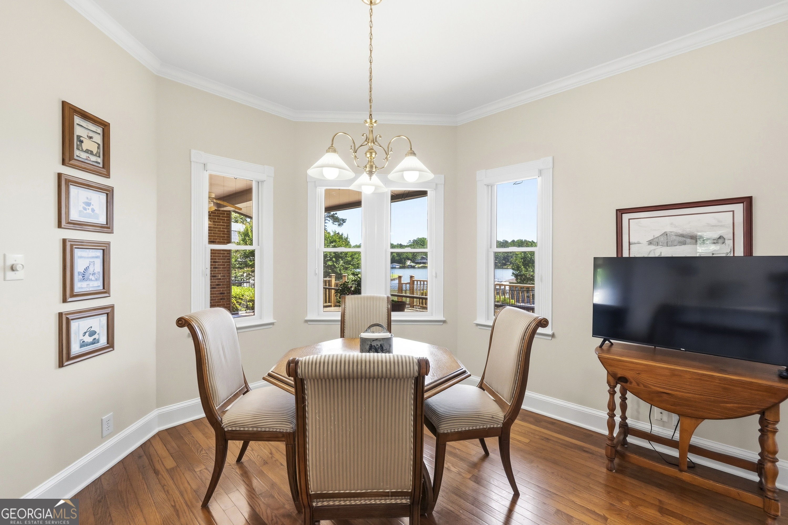 104 Spruce Point Southeast Eatonton, GA 31024 - Photo 19 of 63 a dining room with furniture a flat screen tv and a chandelier