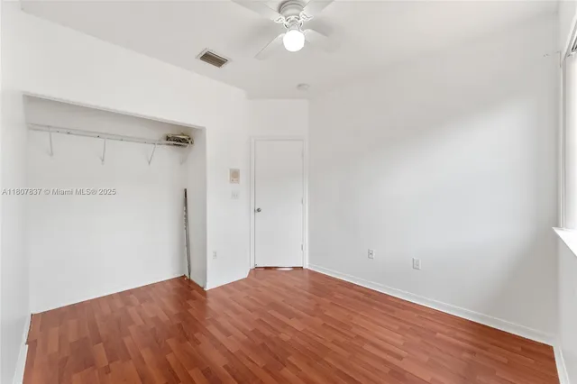 a view of a big room with wooden floor and a ceiling fan