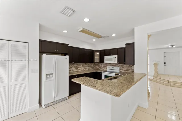 a kitchen with stainless steel appliances granite countertop a refrigerator and a sink