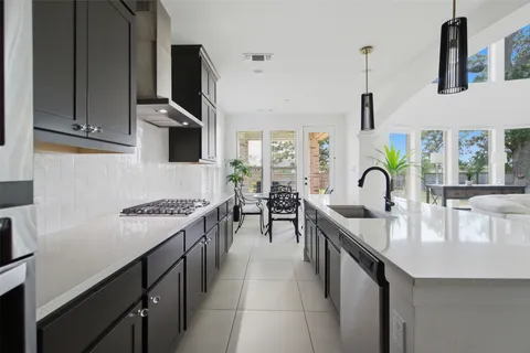 a kitchen with kitchen island granite countertop a stove and a sink with granite countertops